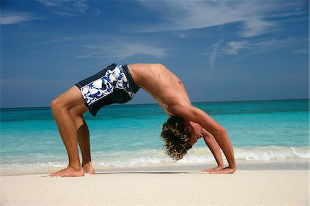 paradise island bahamas beach - Man practicing yoga on tropical beach Stock Photo - Premium Royalty-Free, Code: 614-08870313