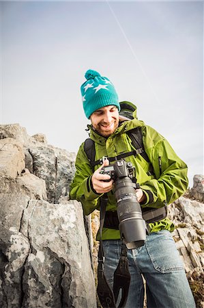 Hiker taking pictures in rural landscape Stock Photo - Premium Royalty-Free, Code: 614-08870427