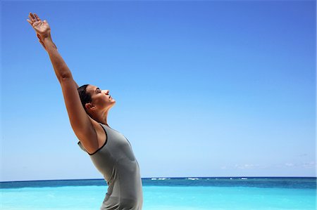 simsearch:633-06406424,k - Woman stretching on tropical beach Photographie de stock - Premium Libres de Droits, Code: 614-08870586