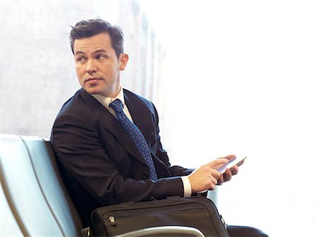 simsearch:6108-06166081,k - Businessman using cell phone in airport Stock Photo - Premium Royalty-Free, Code: 614-08871005