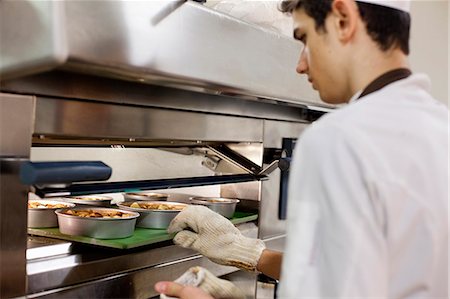 Baker putting food in oven in kitchen Stockbilder - Premium RF Lizenzfrei, Bildnummer: 614-08871089