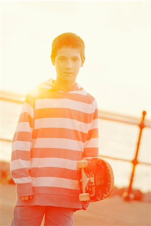 simsearch:614-09258754,k - Boy holding skateboard outdoors Photographie de stock - Premium Libres de Droits, Code: 614-08871152