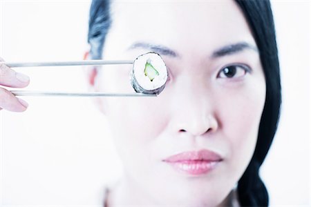 simsearch:614-08871355,k - Woman holding piece of sushi over eye Stock Photo - Premium Royalty-Free, Code: 614-08871337