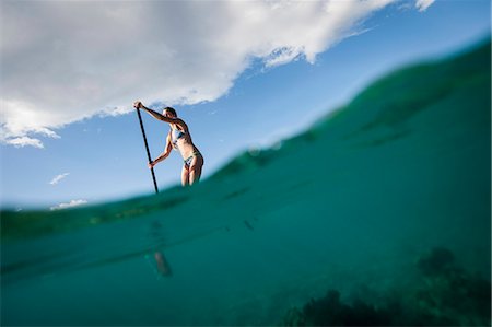 Woman paddleboarding on ocean Stock Photo - Premium Royalty-Free, Code: 614-08871422