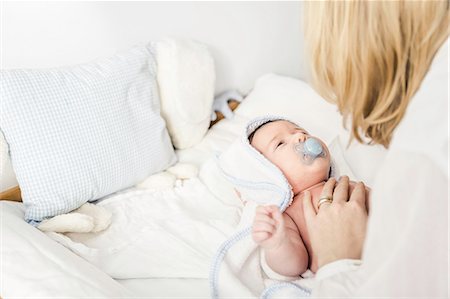 simsearch:6108-06906084,k - Mid adult mother putting baby boy in cot Stock Photo - Premium Royalty-Free, Code: 614-08871608