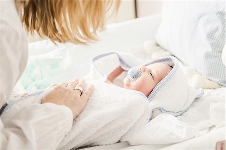 simsearch:6119-07845671,k - Mid adult mother putting baby boy in cot Fotografie stock - Premium Royalty-Free, Codice: 614-08871609