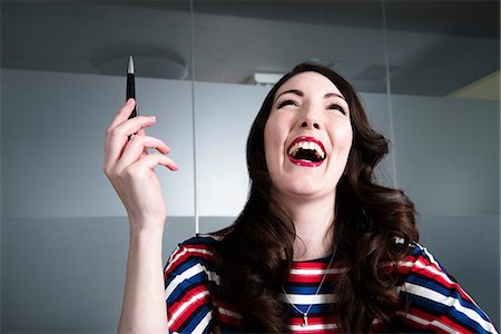 striped woman dress - Woman with head thrown back laughing madly in office environment Stock Photo - Premium Royalty-Free, Code: 614-08871783