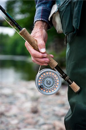 fly fishing on white - Man with fly fishing rod and reel, close up Stock Photo - Premium Royalty-Free, Code: 614-08872038