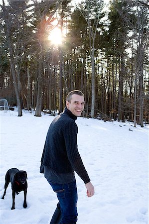 dog looking over shoulder - Man with dog in forest in the snow Stock Photo - Premium Royalty-Free, Code: 614-08872480