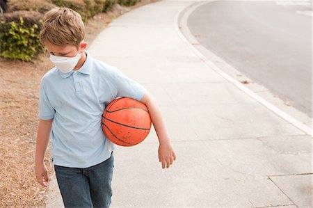 sick outside - Boy wearing dust mask holding basketball Photographie de stock - Premium Libres de Droits, Code: 614-08872544