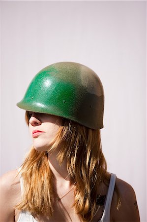 Woman wearing soldier's helmet Stock Photo - Premium Royalty-Free, Code: 614-08872553
