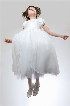 Girl wearing white dress, jumping Photographie de stock - Premium Libres de Droits, Code: 614-08872627