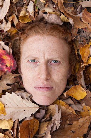 simsearch:614-06402825,k - Woman's face peering through autumn leaves Foto de stock - Royalty Free Premium, Número: 614-08872630