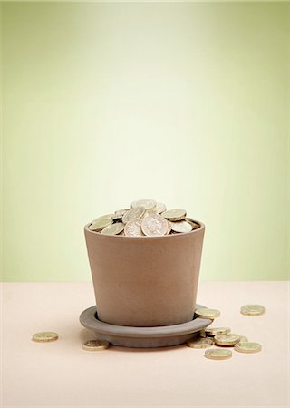 piles of cash pounds - Plant pot full of pound coins Photographie de stock - Premium Libres de Droits, Code: 614-08872771