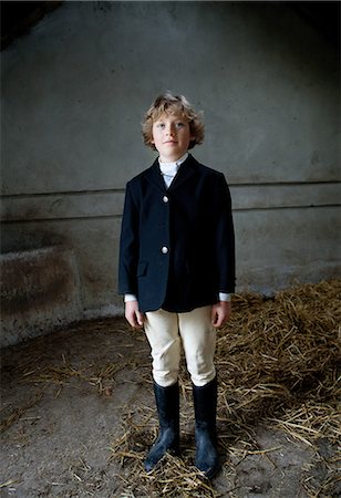 simsearch:614-03469507,k - Boy standing in horse riding clothes in stable Fotografie stock - Premium Royalty-Free, Codice: 614-08872825