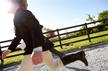 equestrian - Boys running in horse riding clothes Stock Photo - Premium Royalty-Free, Code: 614-08872823
