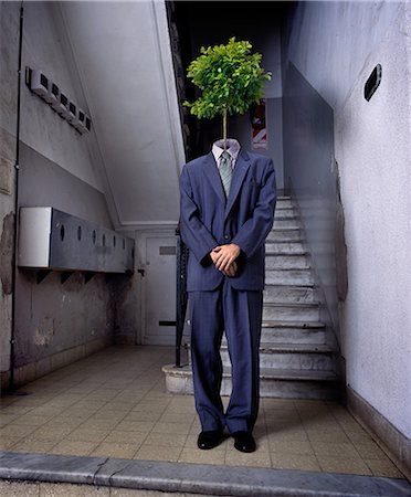 Businessman standing in lobby with tree for a head Stock Photo - Premium Royalty-Free, Code: 614-08872849