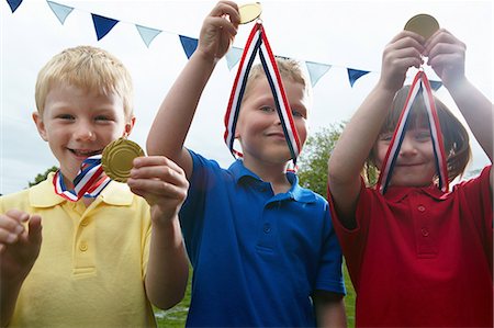 Three children holding sports medals on the school playing field Stockbilder - Premium RF Lizenzfrei, Bildnummer: 614-08872850