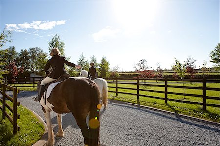 ranches with fenced livestock - Boys riding horses in sunlight Stock Photo - Premium Royalty-Free, Code: 614-08872921