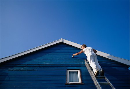 A man painting the weatherboarding of a house Stock Photo - Premium Royalty-Free, Code: 614-08872969