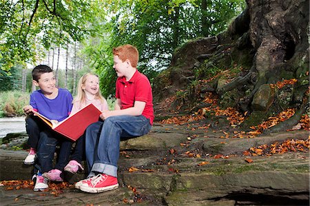 simsearch:6102-08542316,k - Three children enjoying a book together Foto de stock - Sin royalties Premium, Código: 614-08872979