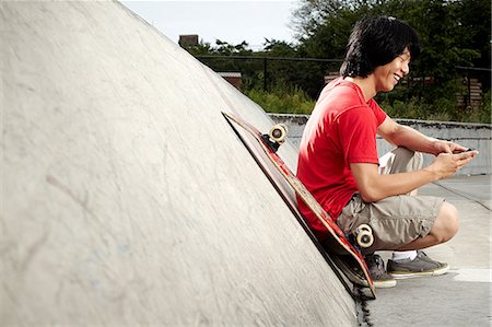simsearch:695-05768222,k - Young skateboarder using mobile phone in skate park Foto de stock - Sin royalties Premium, Código: 614-08873029