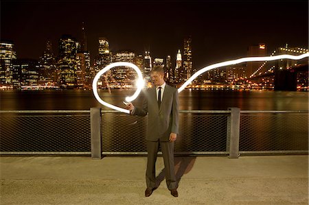 Businessman making light trail at night by East River, Brooklyn, USA Stock Photo - Premium Royalty-Free, Code: 614-08873064