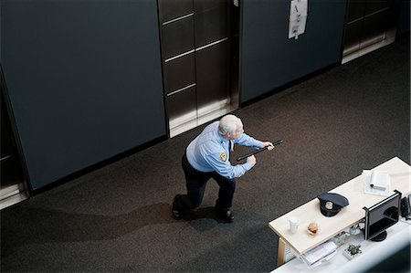 Security guard brandishing baton in office Fotografie stock - Premium Royalty-Free, Codice: 614-08873082