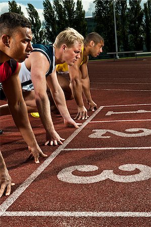 Athletes preparing to race on sportstrack Stock Photo - Premium Royalty-Free, Code: 614-08873103