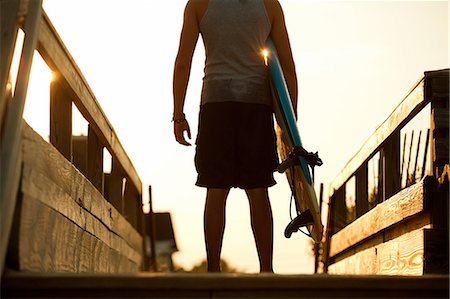 Teenager standing in anticipation ready to surf Stock Photo - Premium Royalty-Free, Code: 614-08873157