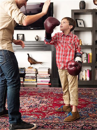 Father teaching son to box in living room Photographie de stock - Premium Libres de Droits, Code: 614-08873230