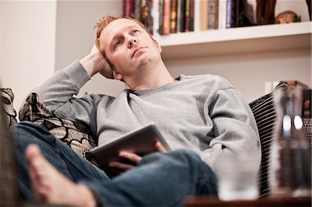 simsearch:614-06311914,k - Mid adult man using digital tablet on sofa Stock Photo - Premium Royalty-Free, Code: 614-08873349