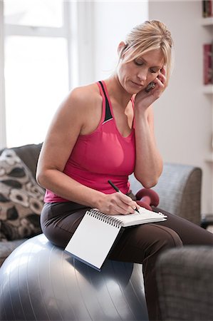 simsearch:614-01623526,k - Mid adult woman taking notes on the phone at home Stock Photo - Premium Royalty-Free, Code: 614-08873360