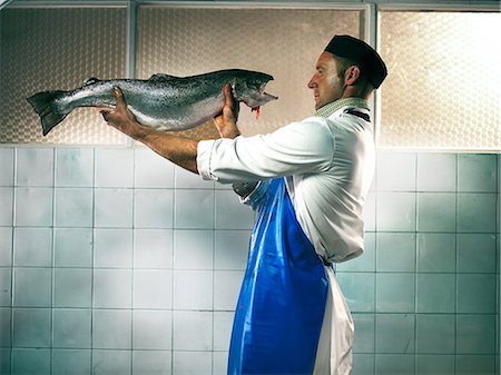 Fishmonger face to face with fish Stock Photo - Premium Royalty-Free, Code: 614-08873472
