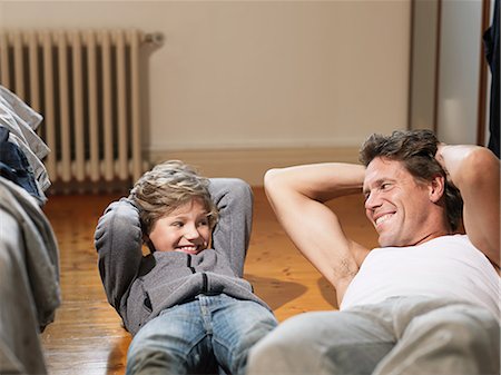 exercise sit up - Mature man and son performing exercises in bedroom Stock Photo - Premium Royalty-Free, Code: 614-08873600