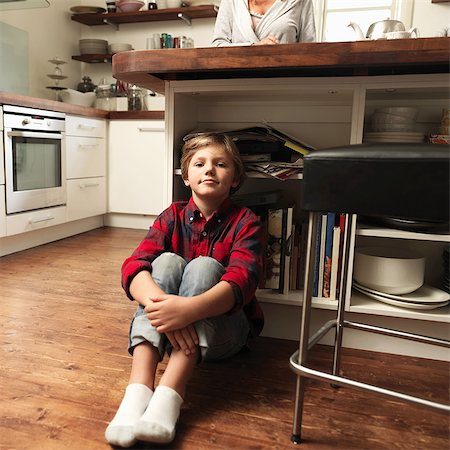 Portrait of boy sitting on floor in kitchen Stock Photo - Premium Royalty-Free, Code: 614-08873616