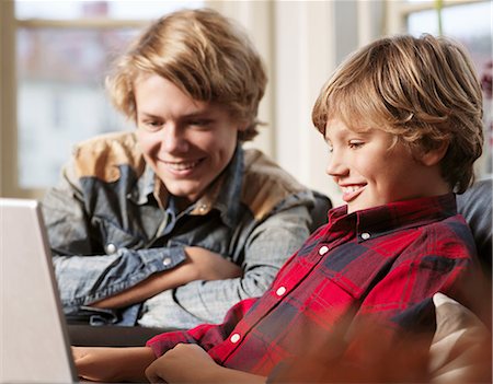 simsearch:614-05955632,k - Teenage boy and brother watching laptop Photographie de stock - Premium Libres de Droits, Code: 614-08873618