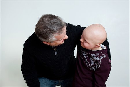 Father son with Down's Syndrome looking at each other Stock Photo - Premium Royalty-Free, Code: 614-08873661