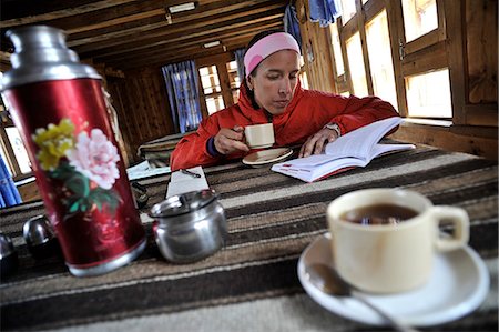 Woman reading guidebook at teahouse, Yak Kharka, Nepal Stock Photo - Premium Royalty-Free, Code: 614-08873718