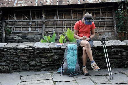 sun visor hat - Woman stops for a break along stone-paved street, Ngadi, Nepal Stock Photo - Premium Royalty-Free, Code: 614-08873710