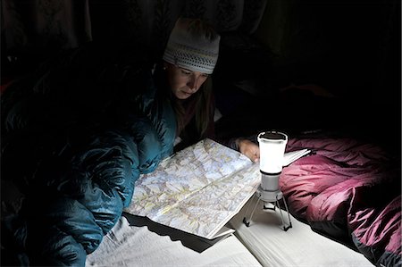 simsearch:614-08873731,k - Woman in sleeping bag, looking at trail map, Yak Kharka, Nepal Foto de stock - Royalty Free Premium, Número: 614-08873720