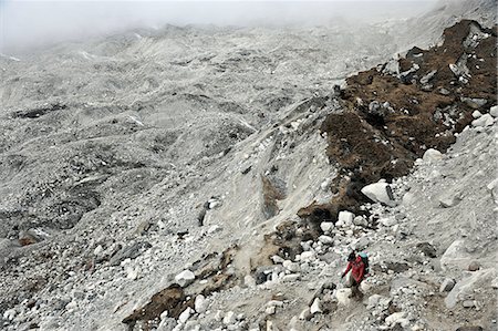 Female trekker descending across the moraine of the Nguzumpa Glacier, Nepal Foto de stock - Sin royalties Premium, Código: 614-08873732