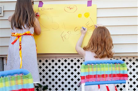 sell lemonade - Girls making sign for selling homemade lemonade Stock Photo - Premium Royalty-Free, Code: 614-08873968