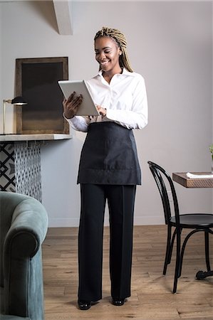 Portrait of waiter in restaurant, using digital tablet Stock Photo - Premium Royalty-Free, Code: 614-08884604