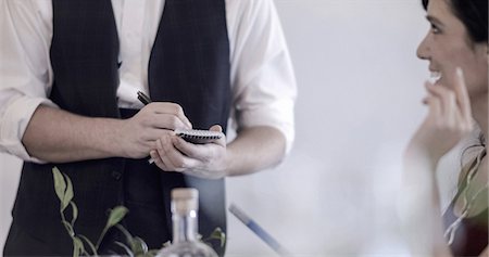 Waiter serving diner in restaurant, using pen and notepad, mid section Foto de stock - Sin royalties Premium, Código: 614-08884608