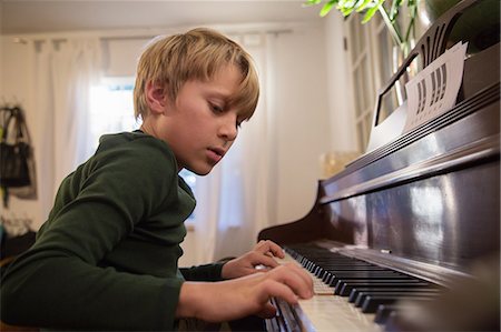 pianiste - Boy playing piano in living room Photographie de stock - Premium Libres de Droits, Code: 614-08884699