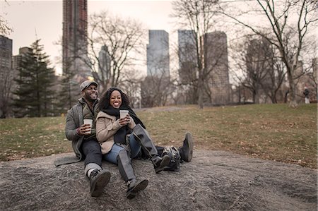 simsearch:614-08879509,k - Couple sitting on rock in park with takeaway coffee Fotografie stock - Premium Royalty-Free, Codice: 614-08884734