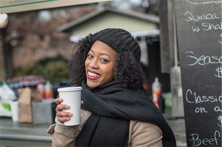 Portrait of young woman with takeaway coffee at city food stall Stock Photo - Premium Royalty-Free, Code: 614-08884733