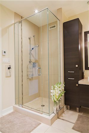 simsearch:614-08488004,k - Contemporary brown laminated wood vanity and clear glass shower stall in bathroom of renovated ground floor apartment in old residential cottage style home Foto de stock - Sin royalties Premium, Código: 614-08884757