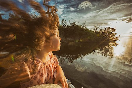 simsearch:614-09027173,k - Young girl enjoying cruise on river, eyes closed basking in sunlight, Homosassa, Florida, USA Stock Photo - Premium Royalty-Free, Code: 614-08884778